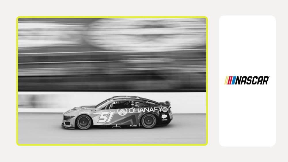 Black-and-white motion-blur shot of the No. 51 Ohanafy NASCAR Cup car next to the NASCAR logo